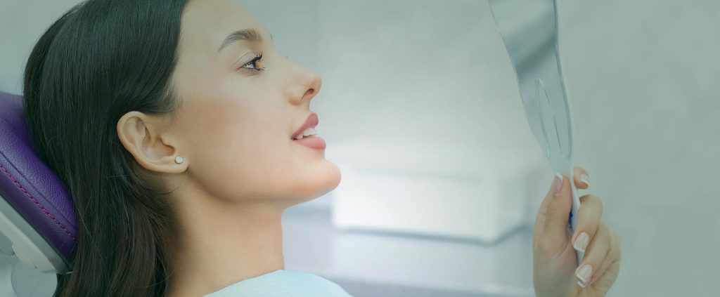 Woman smiling and looking at a mirror